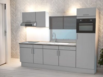 Stijlvolle rechte keuken in cashmere kleur met inbouwapparatuur, wandlamp en decoratief behang met bladmotief.