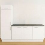 Wit keukenblok met hoge kast en donkergrijs werkblad